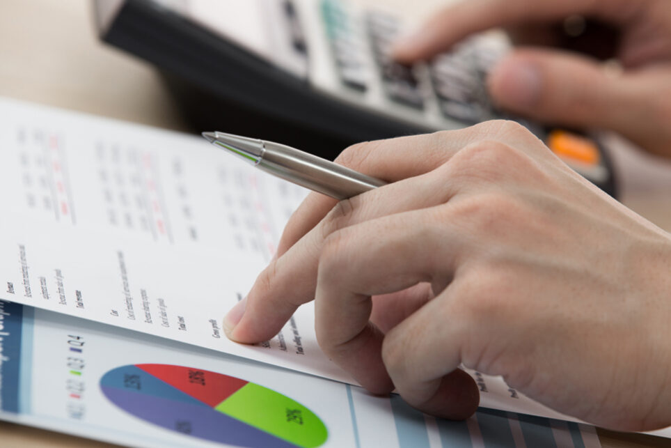 Businessman calculating and checking articles of agreement