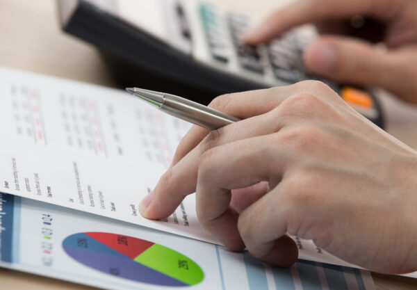 Businessman calculating and checking articles of agreement